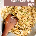 Overhead photo of stir-fried cabbage in a wok with a wooden spatula, text overlay reads 20 Minute Busy Weeknight Cabbage Stir Fry.