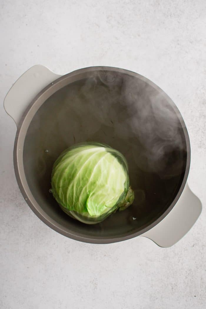 Green cabbage in a large pot of boiling water.