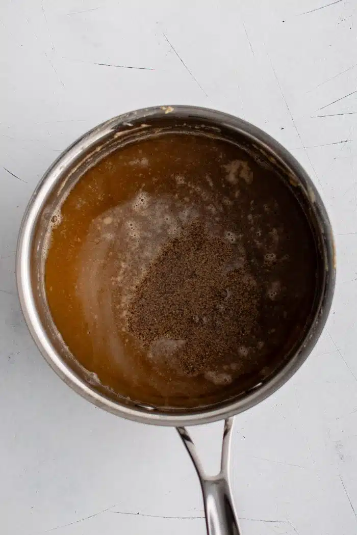 Medium sauce pan filled with roux combined with chicken broth and salt and pepper.