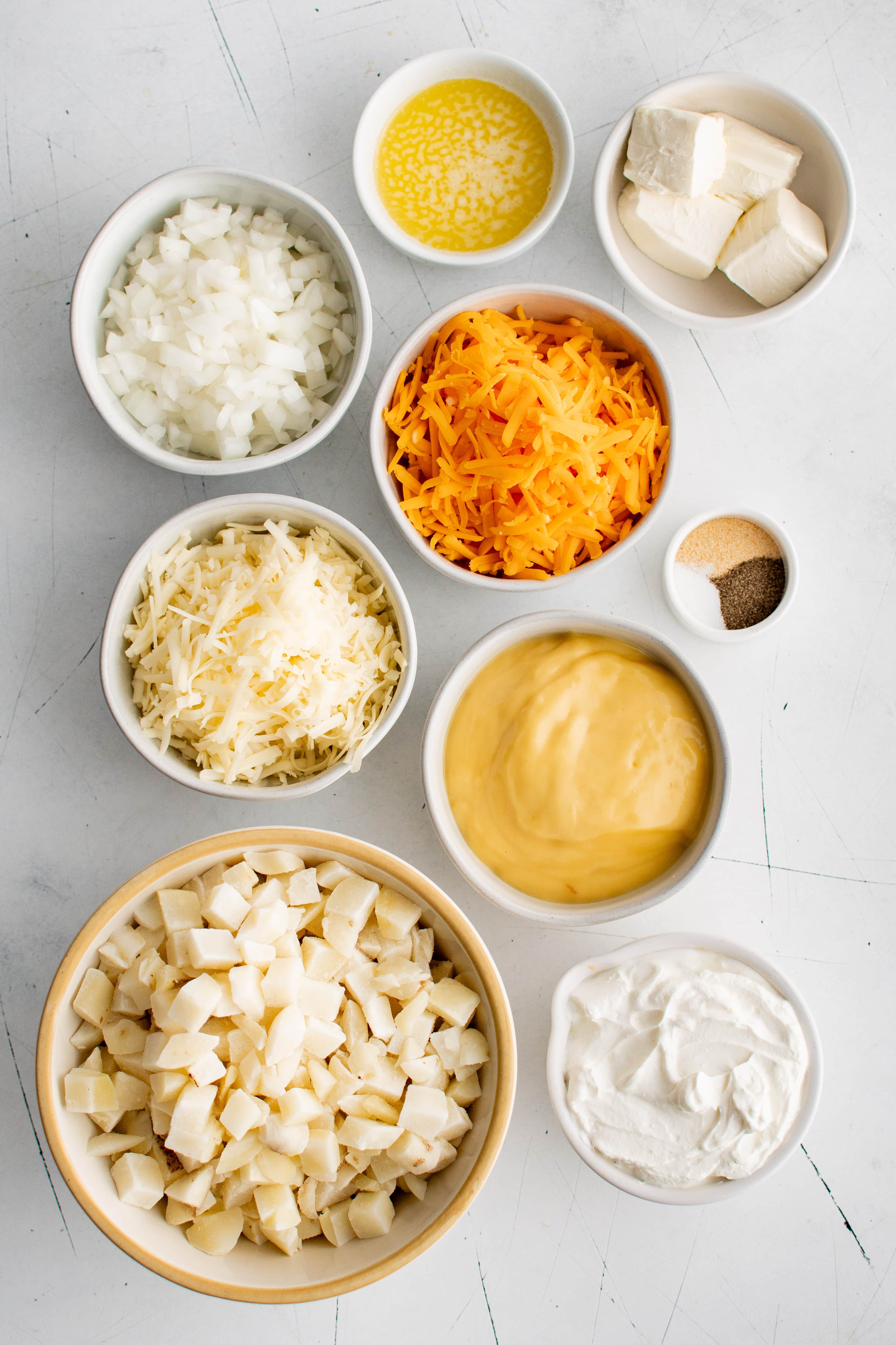 Ingredients needed to make Crockpot Cheesy Potatoes in individual measuring cups and ramekins.