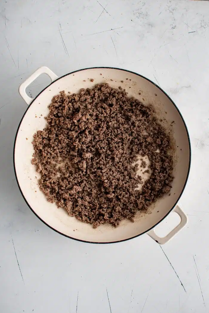 Fully cooked ground beef in a large skillet.