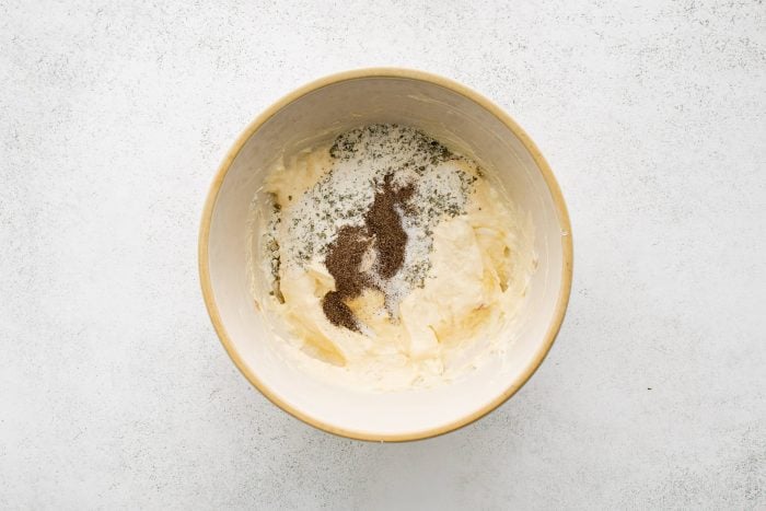 Large mixing bowl filled with mixed together cream cheese and cream of chicken soup and seasoned with ranch seasoning mix.