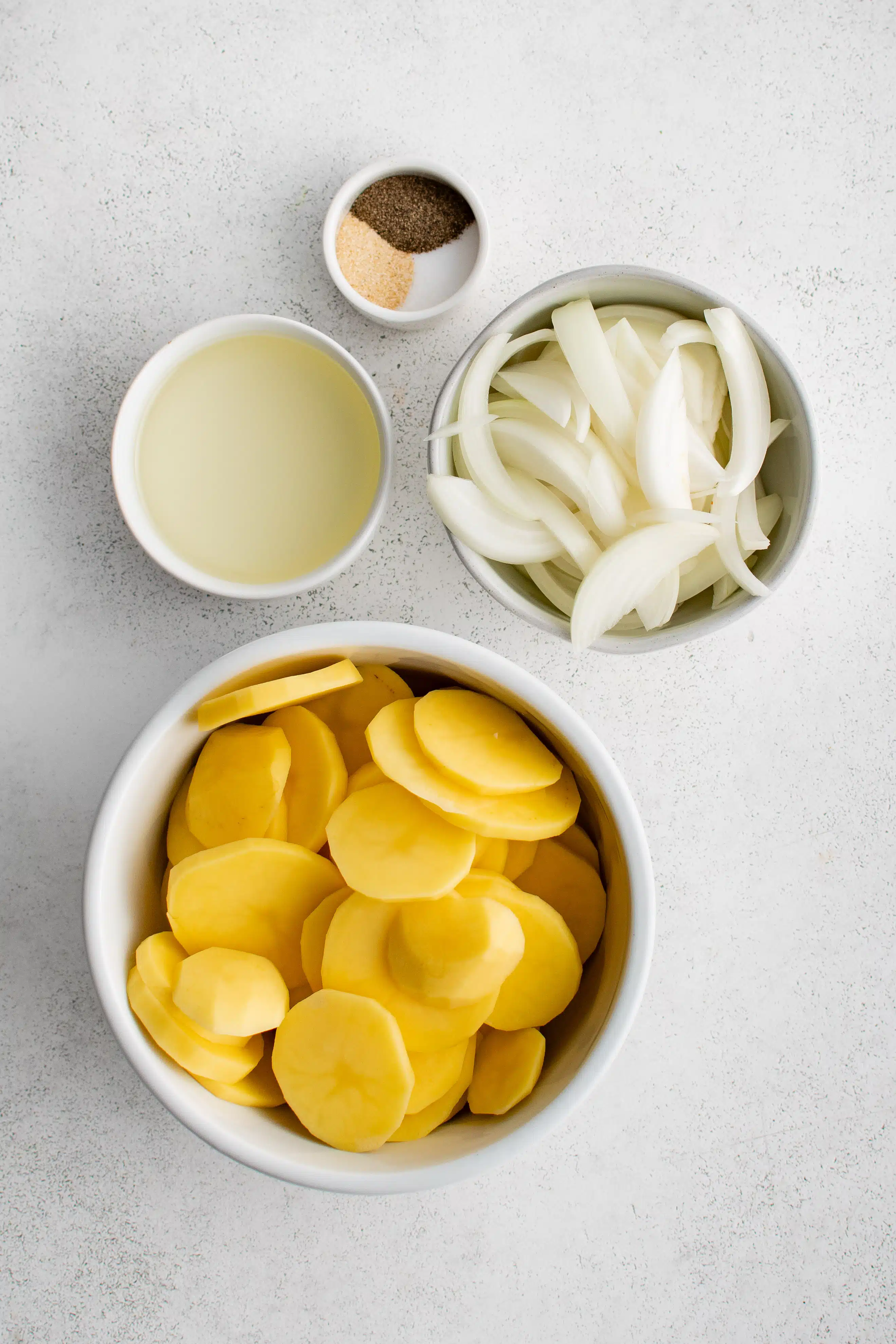 Ingredients needed to make Southern Fried Potatoes and Onions in individual measuring cups and ramekins.