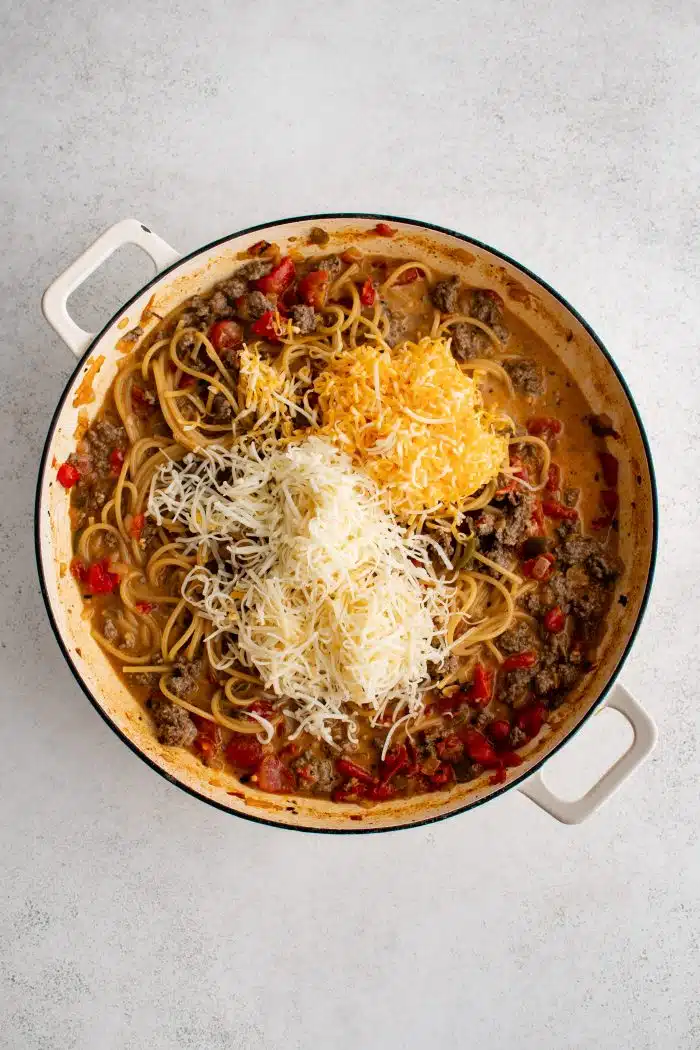 Shredded Colby Jack cheese and shredded Mozzarella cheese added to the cooked spaghetti noodles and seasoned ground beef in a tomato Rotel sauce.