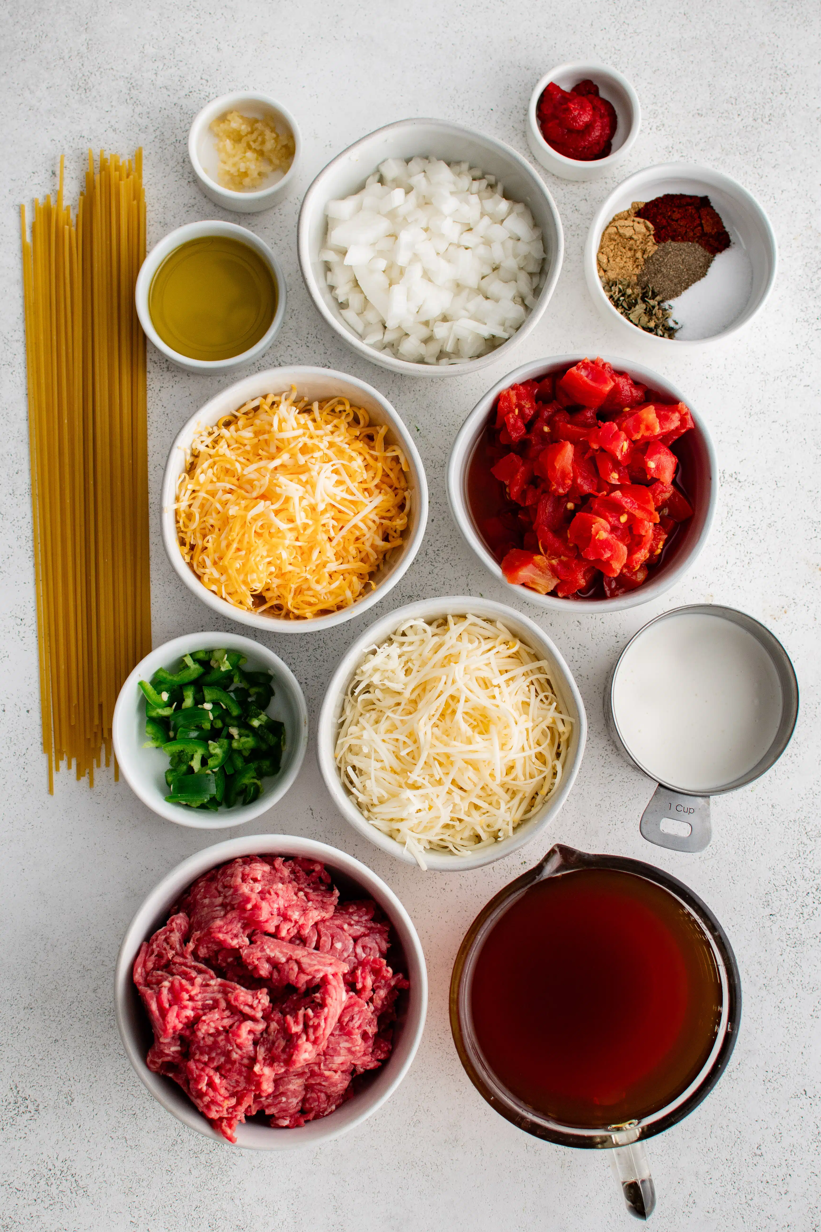 Ingredients needed to make taco spaghetti in individual measuring cups and ramekins.