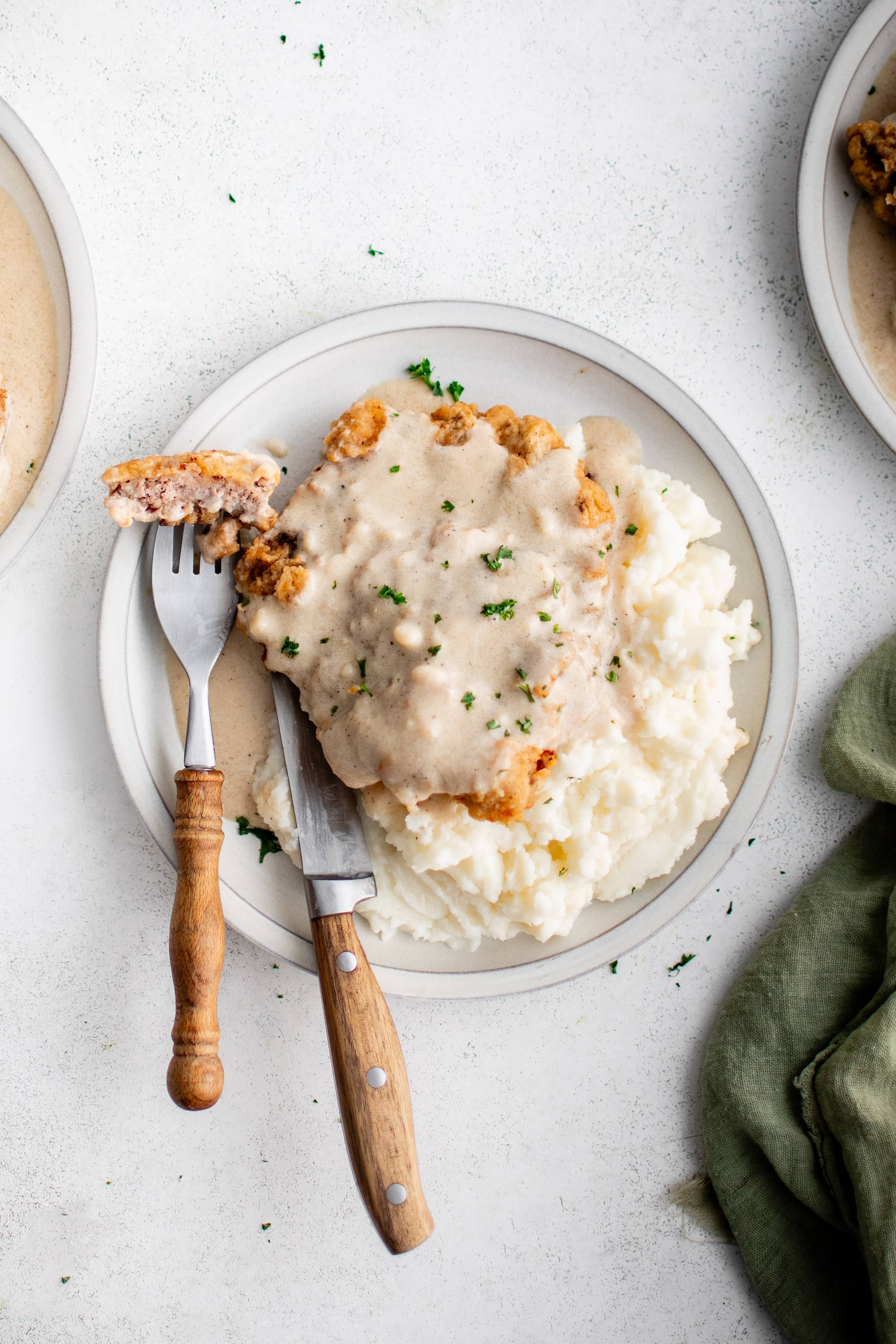 Two pieces of golden brown and crispy chicken fried steak smothered in creamy white gravy served over fluffy mashed potatoes.
