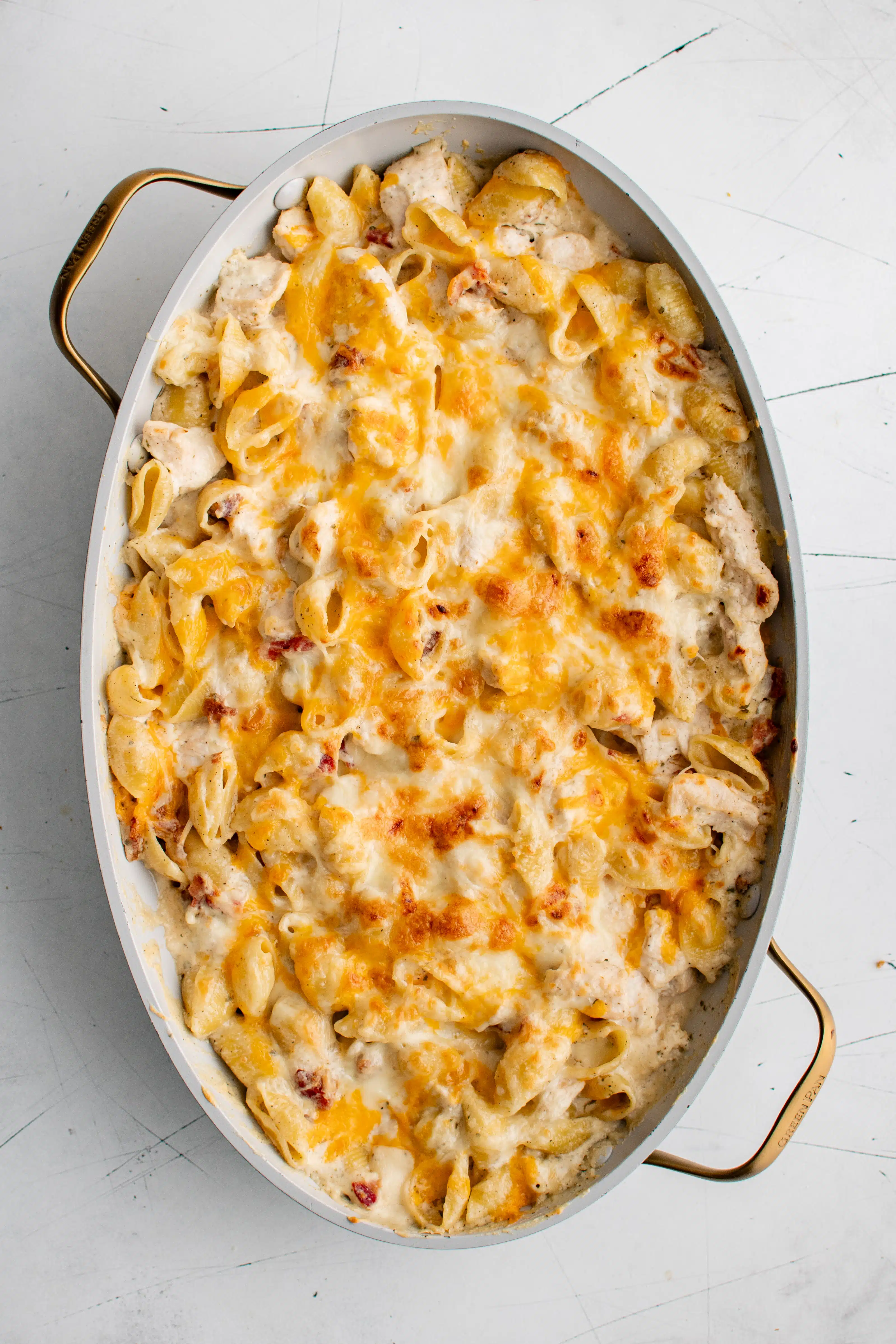 Baked crack chicken with golden gooey melted cheese on top in a large oval baking dish.