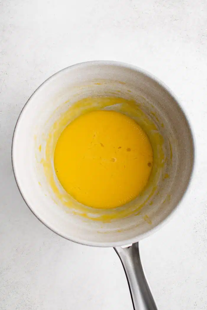 Melted butter whisked into three whisked egg yolks in a medium saucepan.