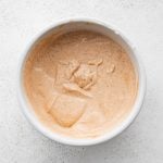 White bowl filled with a mixture of mayonnaise, ketchup, vinegar, dijon, paprika, salt, and black pepper.