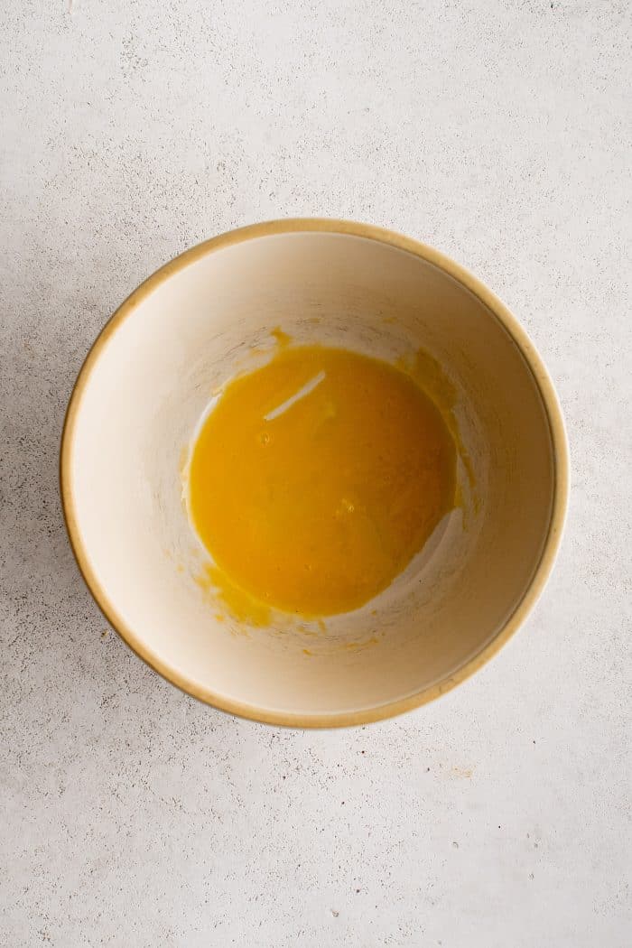 One whisked egg yolk in a small bowl.