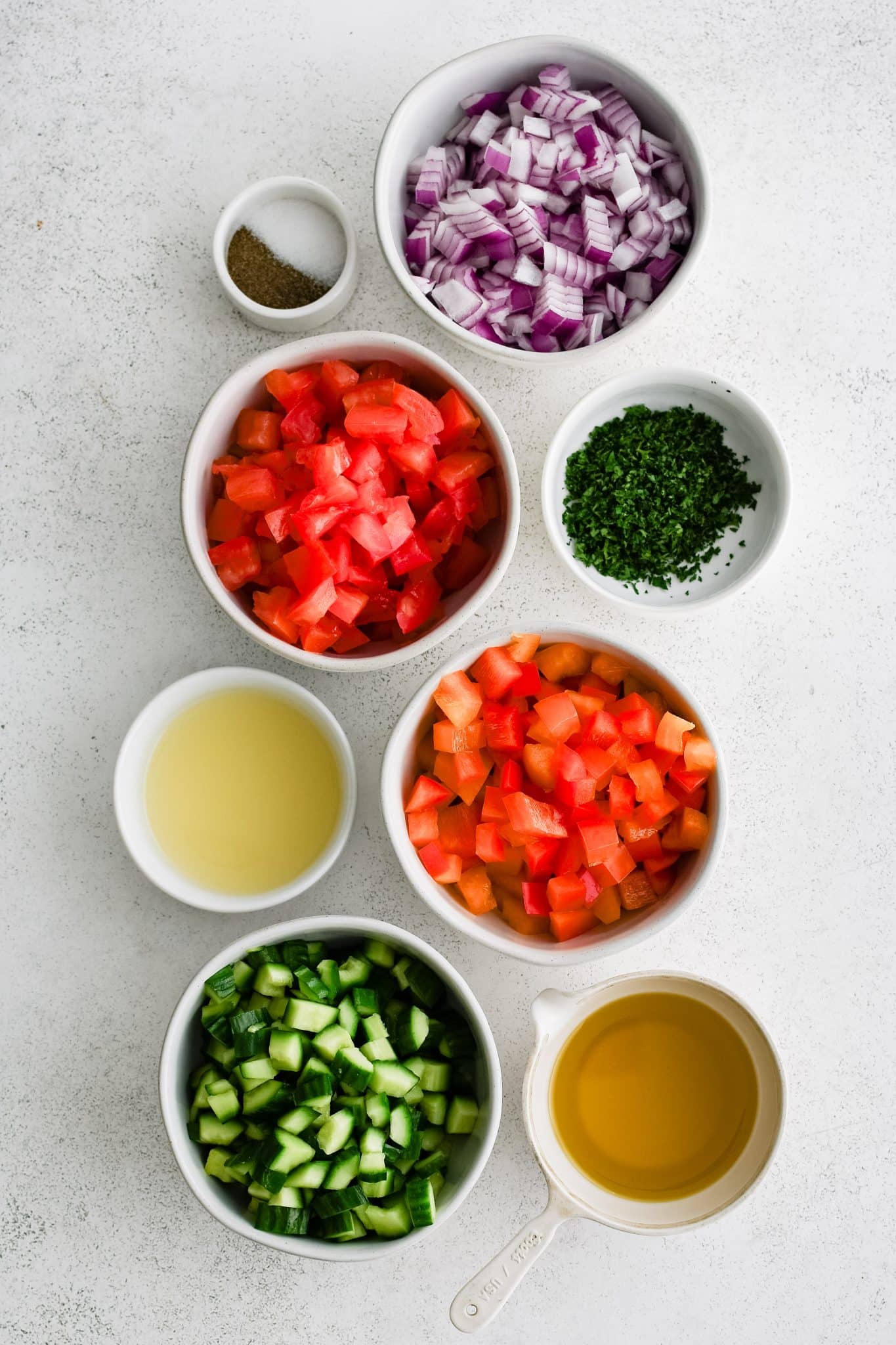 Ingredients for Israeli Salad in individual measuring cups and ramekins.