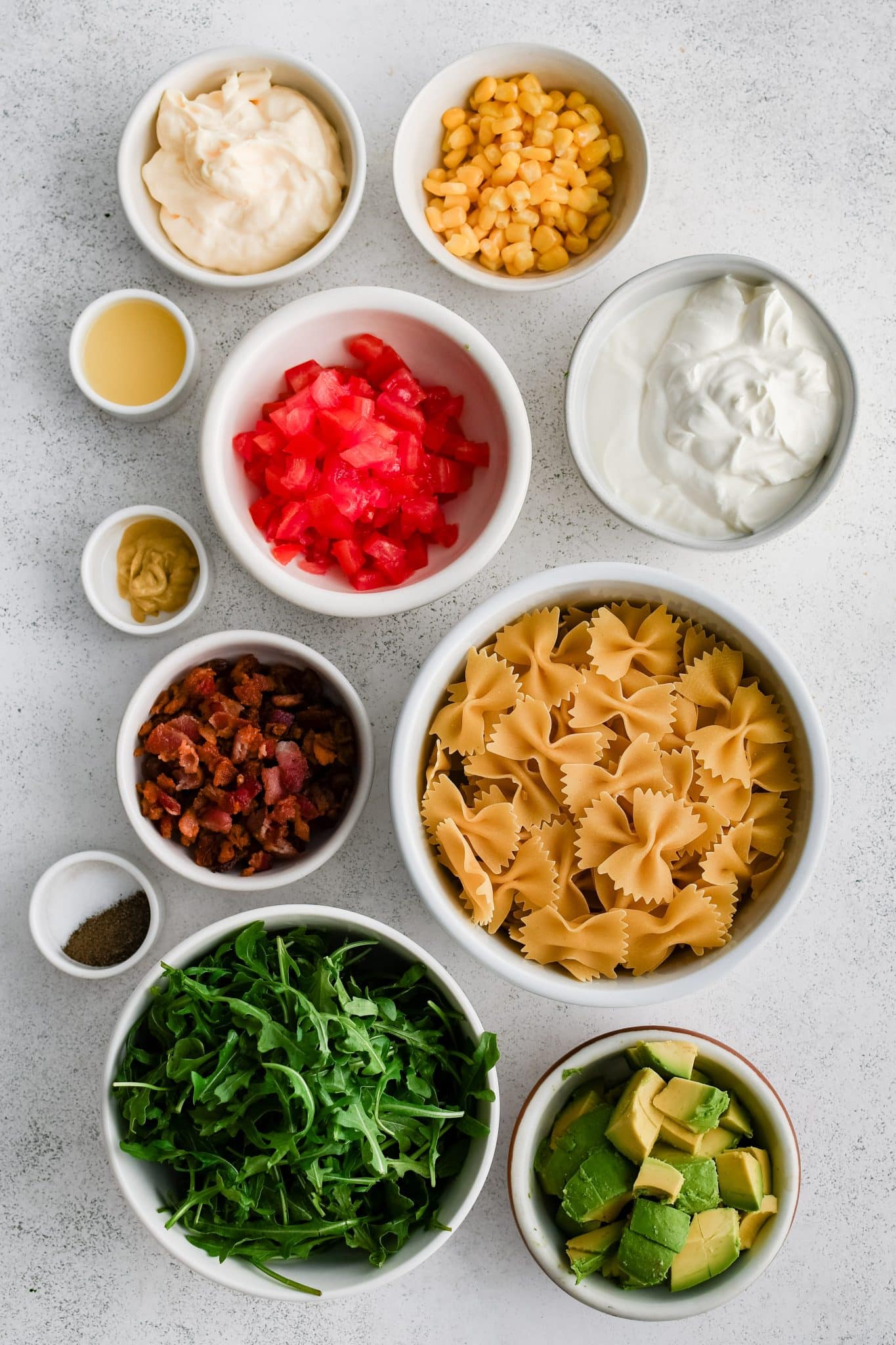 All of the ingredients for BLT Pasta Salad presented in individual measuring cups and ramekins.