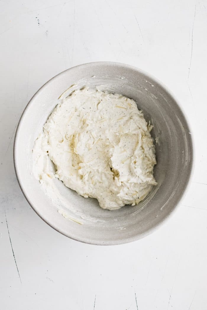 Large white mixing bowl filled with fully combined cream cheese mixture.