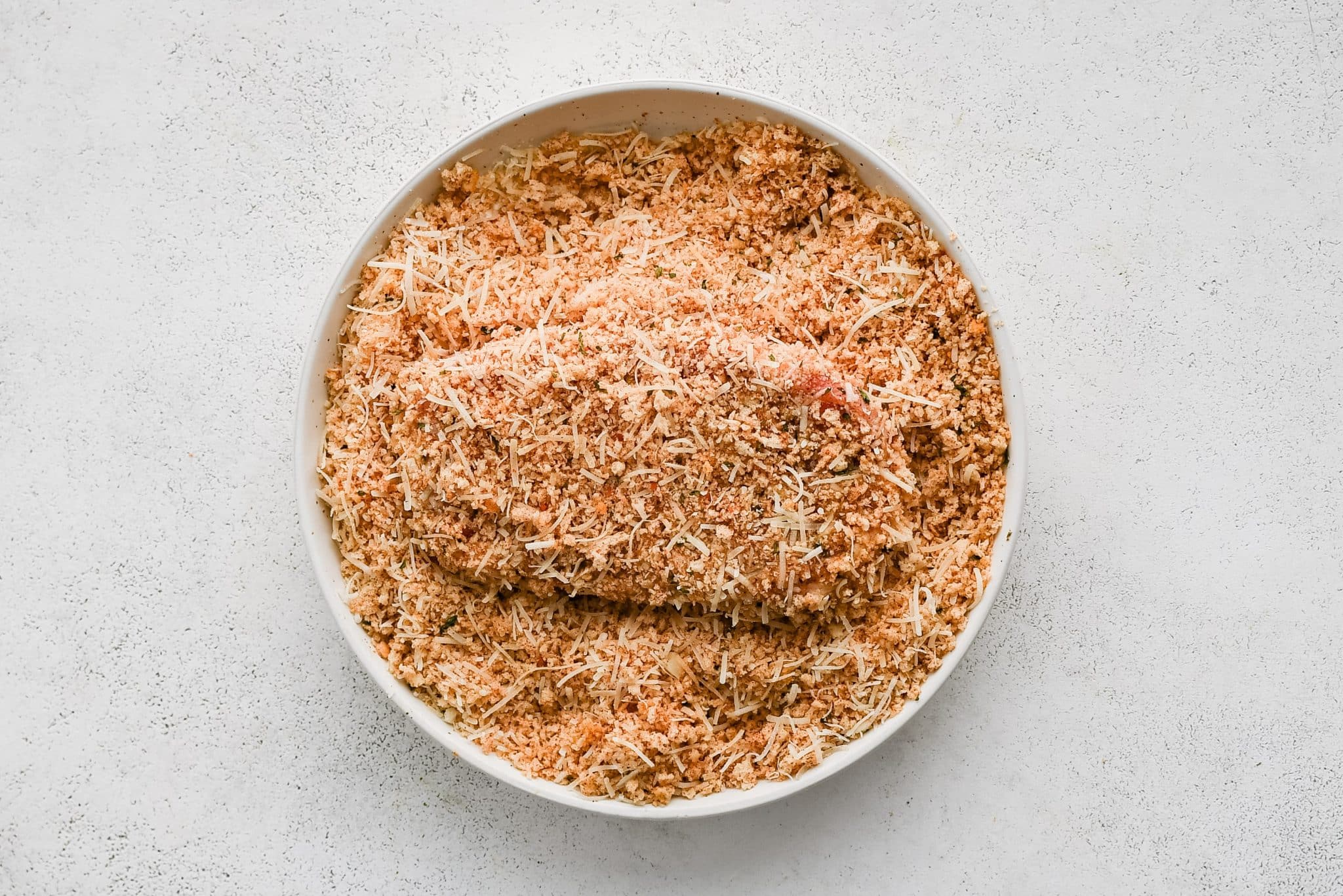 Seasoned pork chop fully covered in a mix of Italian style panko breadcrumbs and shredded Parmesan cheese.