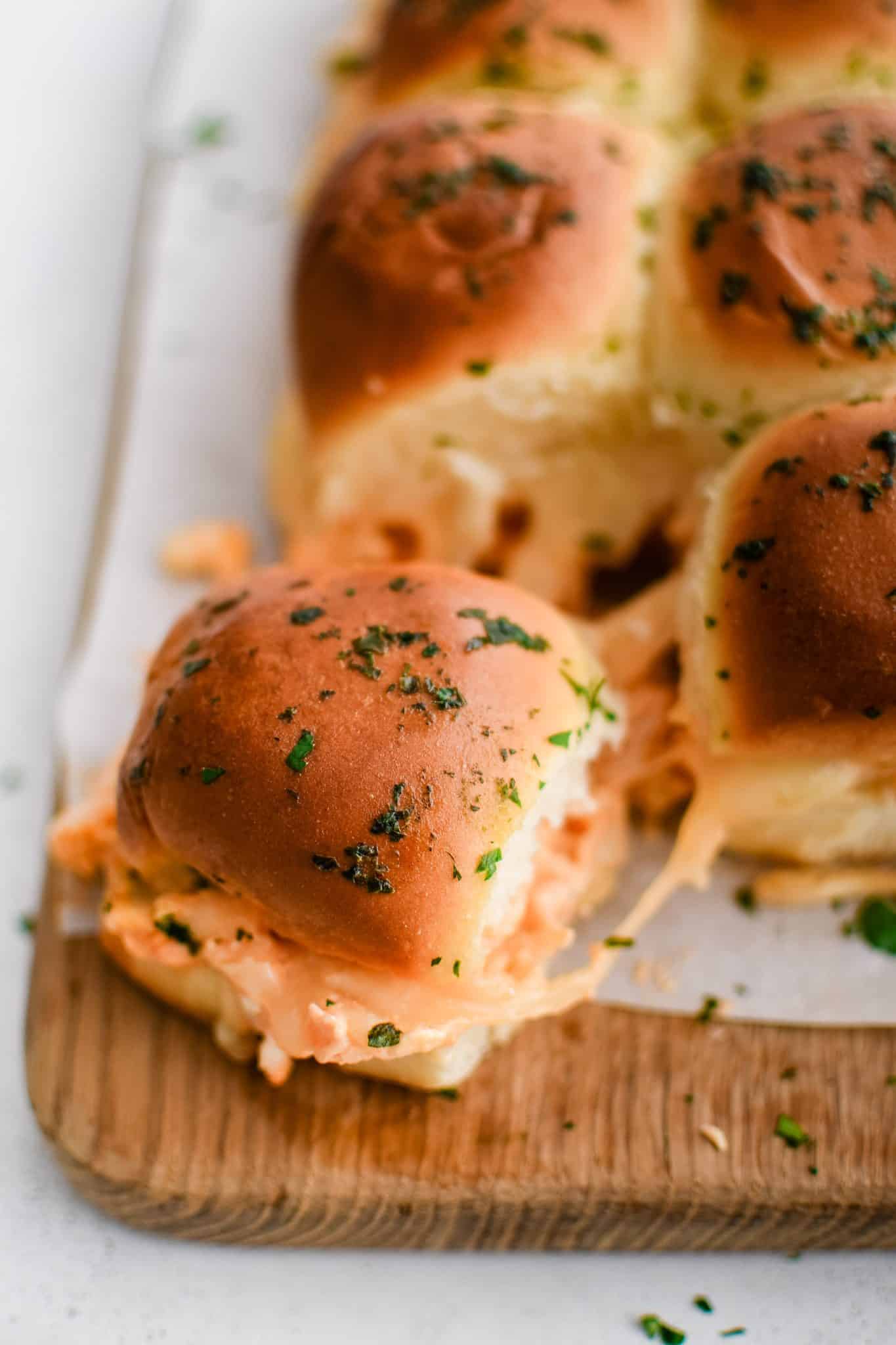 Golden cheesy buffalo chicken slider with herb infused butter brushed over the top bun.
