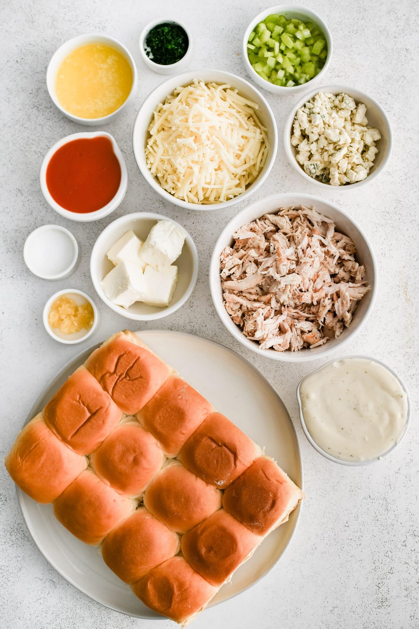 All of the ingredients for chicken Buffalo Chicken Sliders presented in individual measuring cups and ramekins.