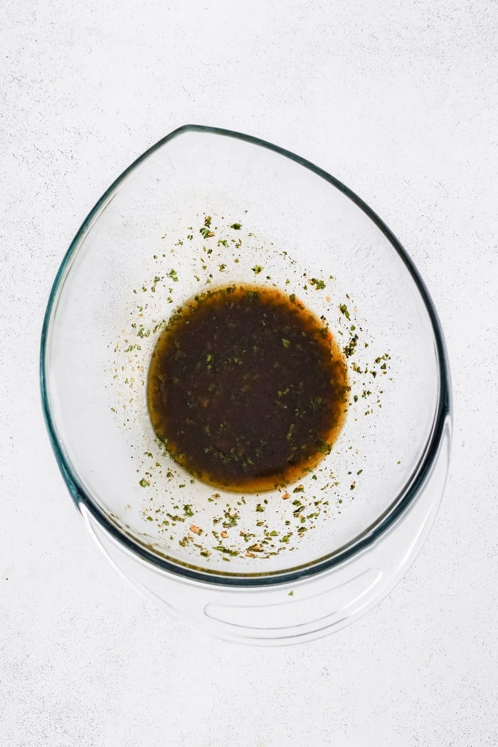Mixed balsamic vinaigrette with herbs in a glass bowl