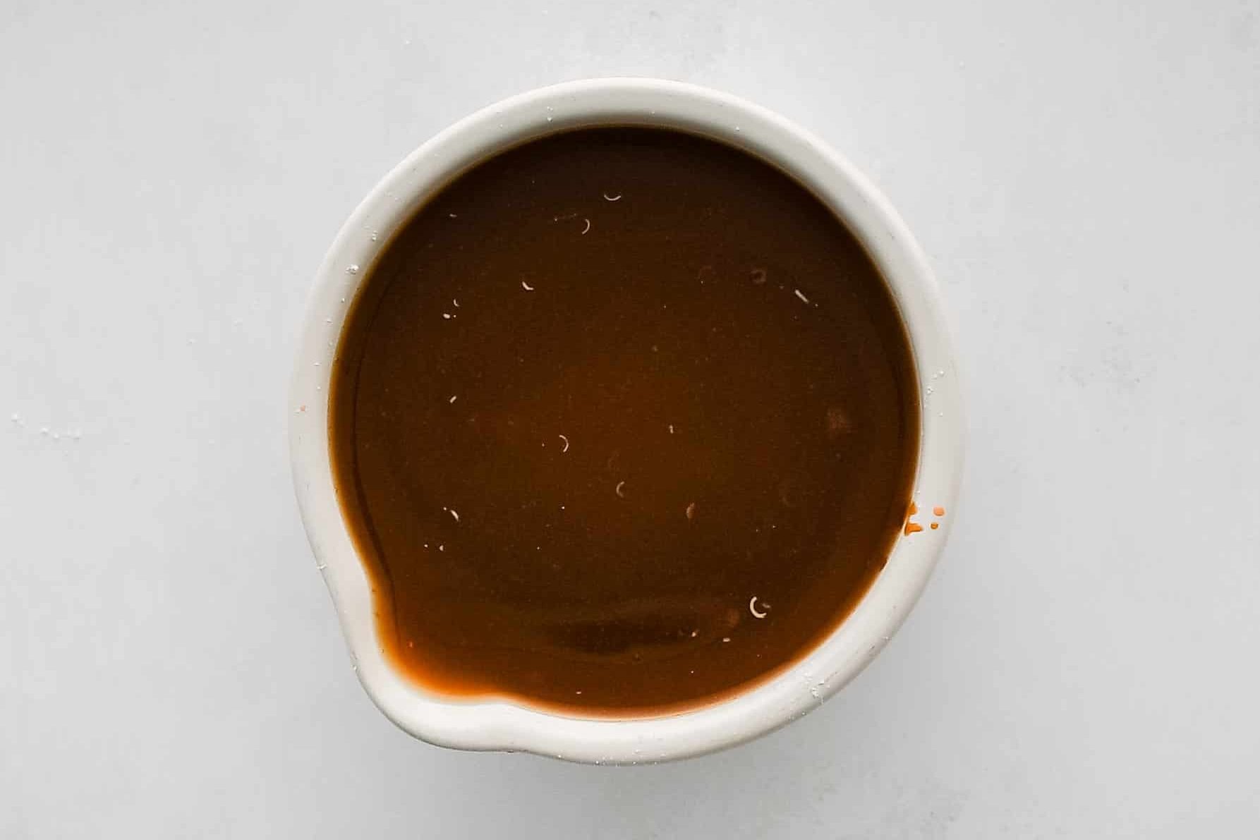Small white bowl filled with homemade stir-fry sauce.