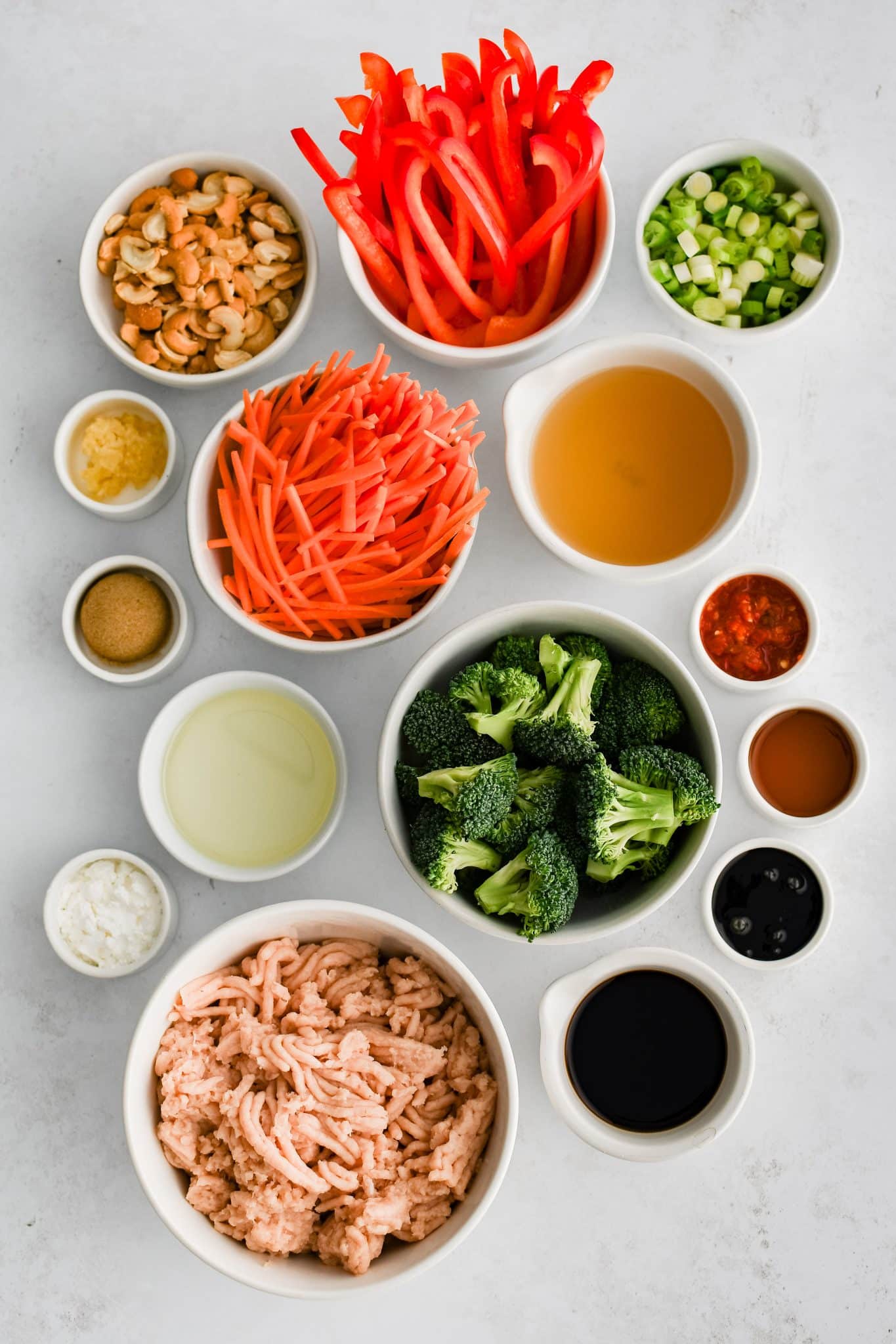 All of the ingredients for ground chicken stir fry recipe presented in individual measuring cups and ramekins.