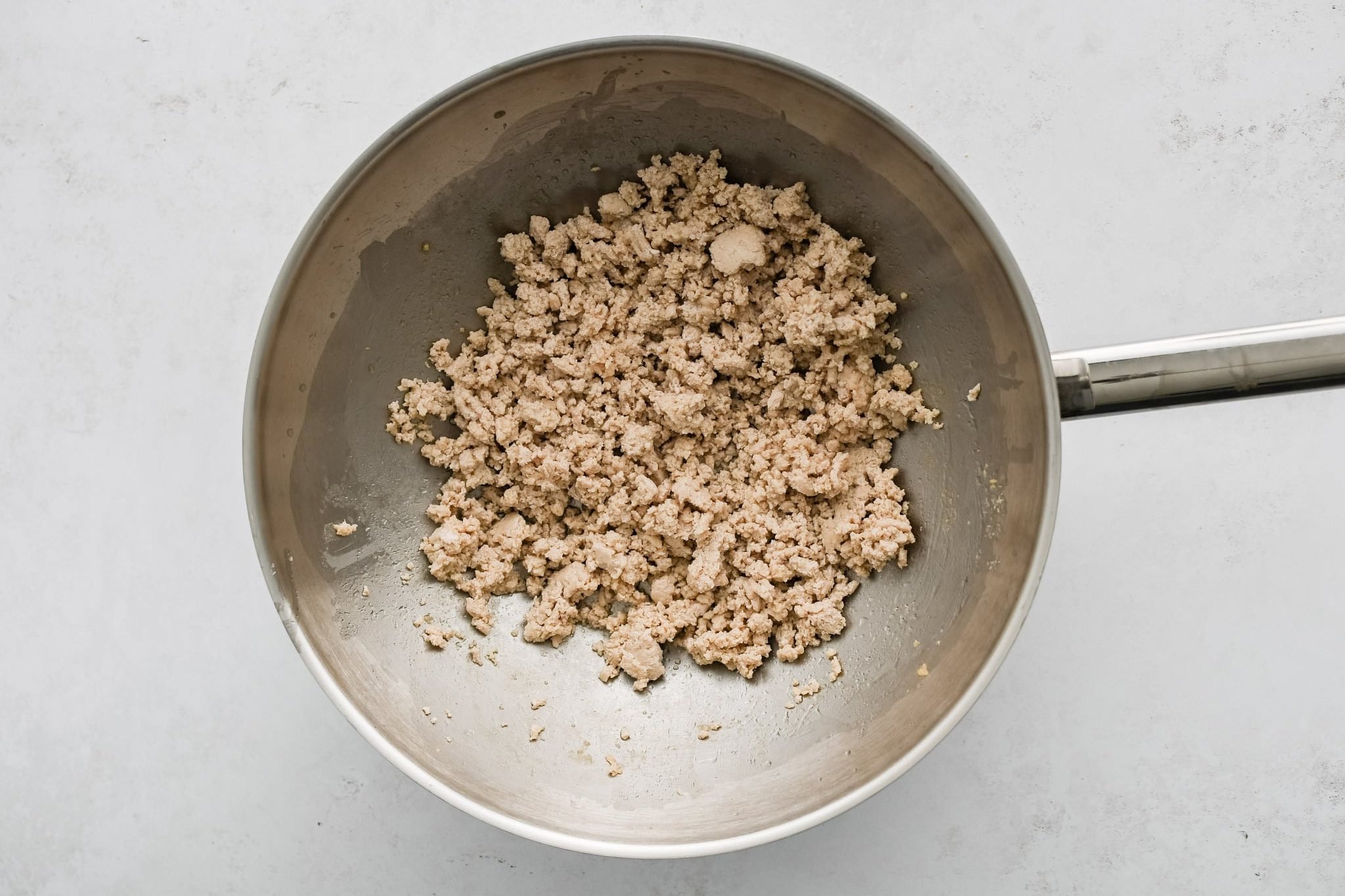 Ground chicken browning in a large wok.