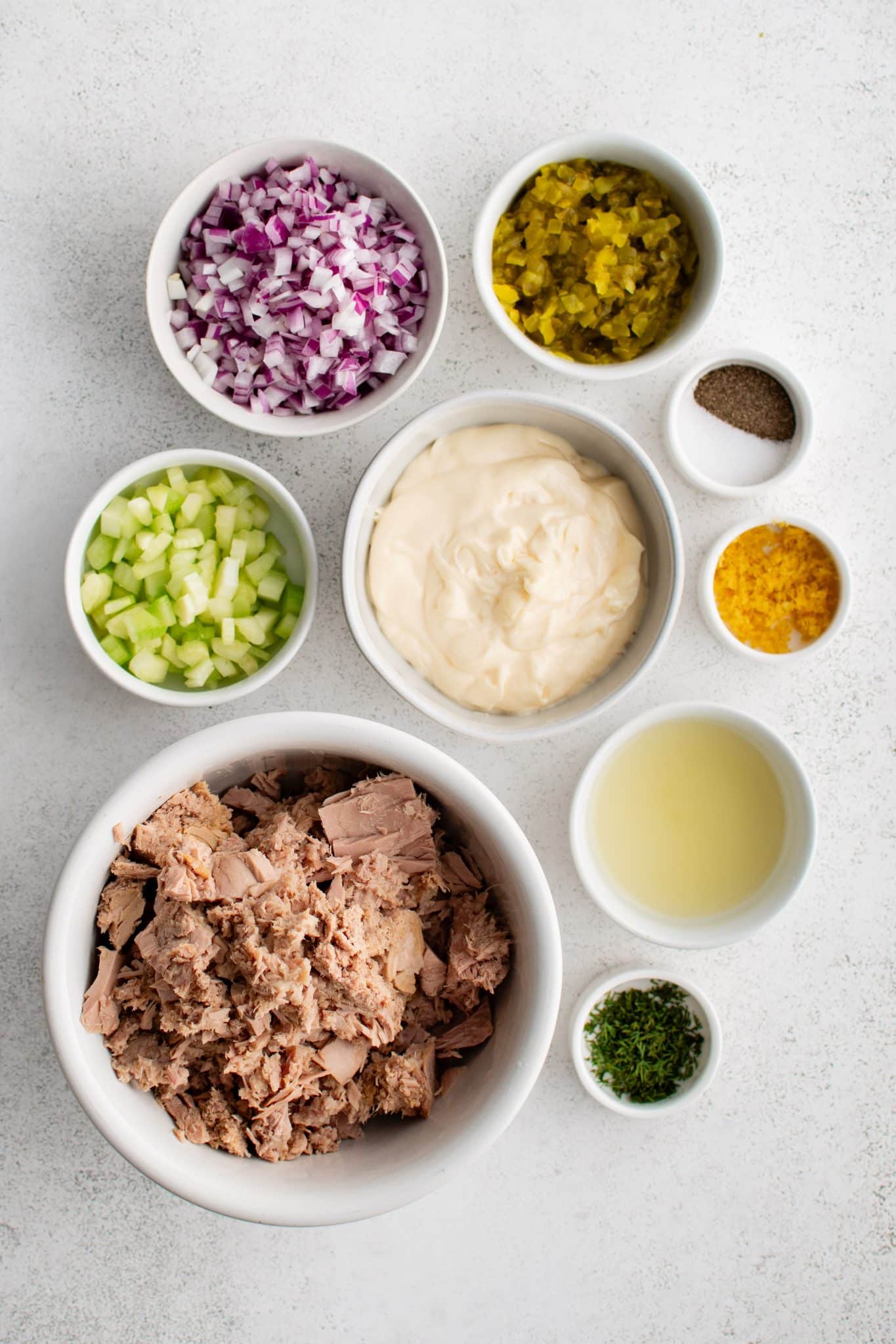 All of the ingredients for Tuna Salad presented in individual measuring cups and ramekins.