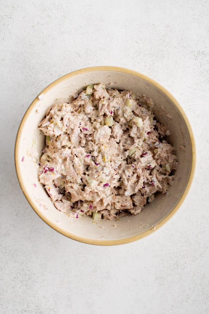 Large mixing bowl filled with the best tuna salad recipe made with canned chunk tuna, diced celery and red onion, dill pickle relish, and fresh dill in a creamy mayonnaise dressing.
