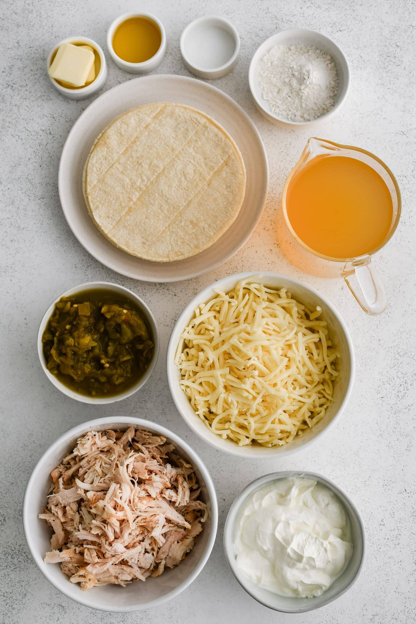 All of the ingredients for sour cream chicken enchiladas recipe presented in individual measuring cups and ramekins.