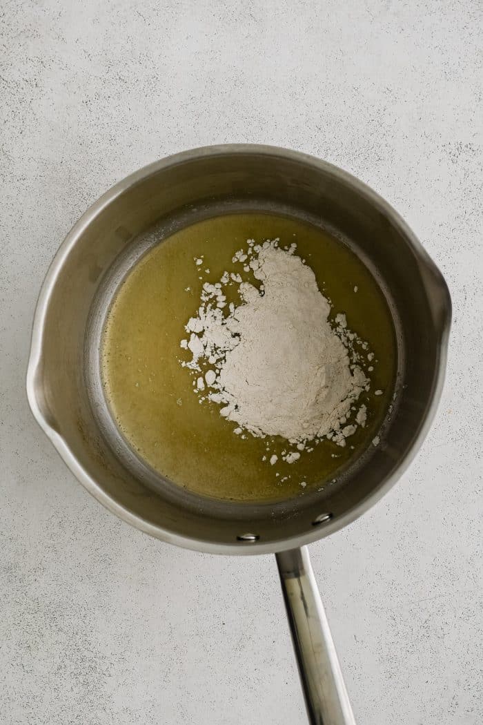 Medium saucepan filled with melted butter, olive oil, and all-purpose flour.