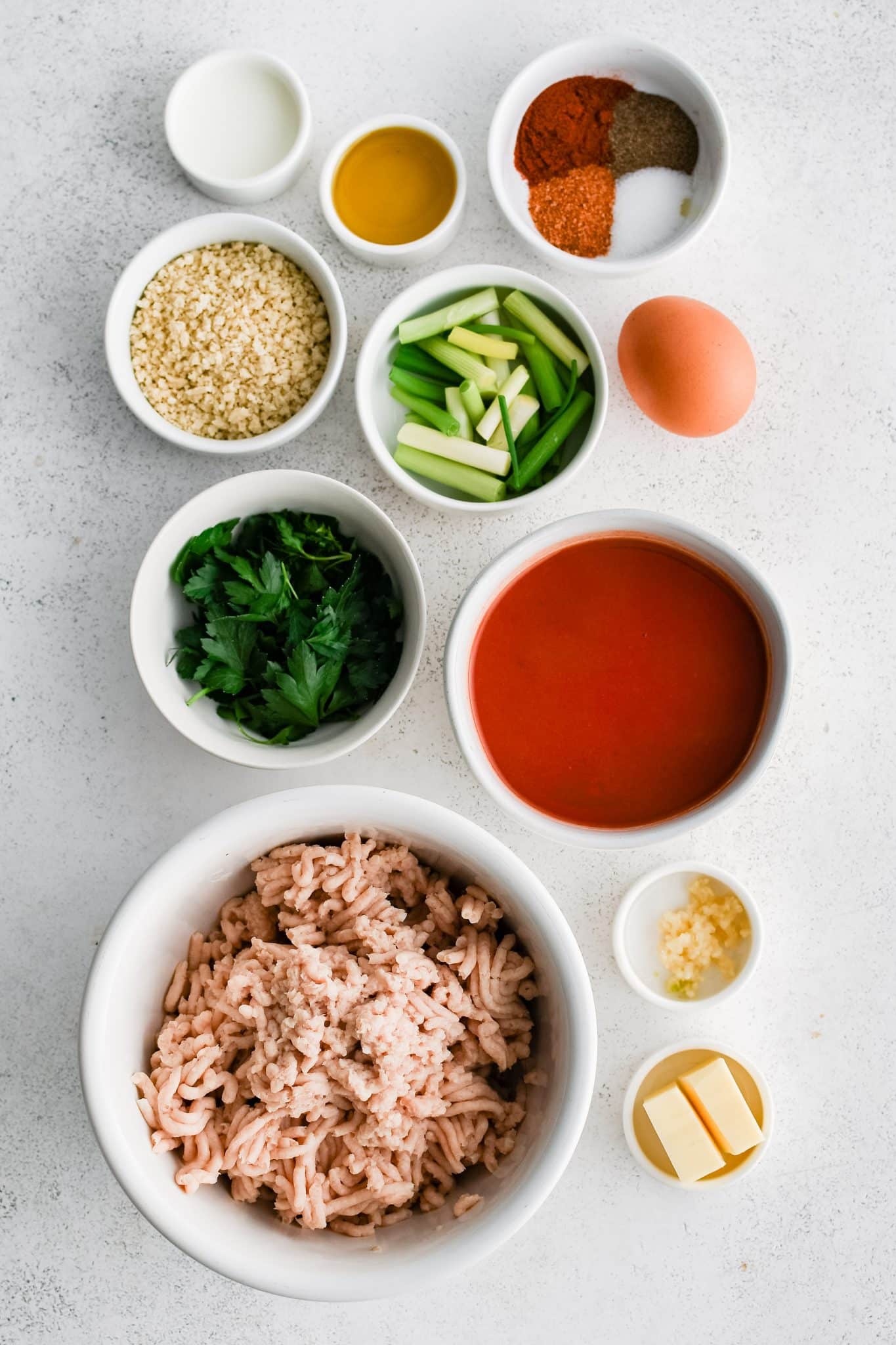 All of the ingredients for homemade buffalo chicken meatballs presented in individual measuring cups and ramekins.