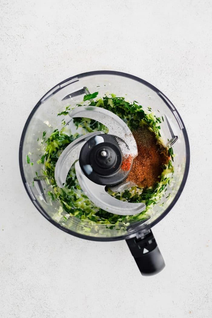 One bunch of finely minced green onions and one bunch of finely minced fresh parsley in a small food processor with paprika, salt, pepper, and Cajun seasoning.