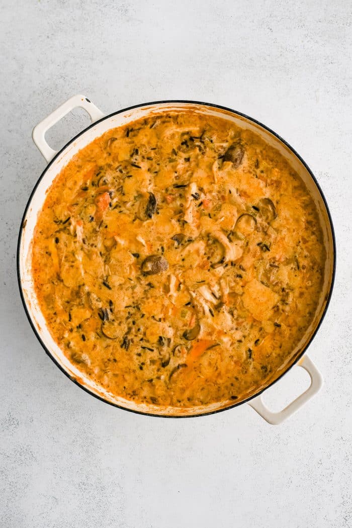 Partially baked chicken and wild rice casserole in a large round casserole dish.