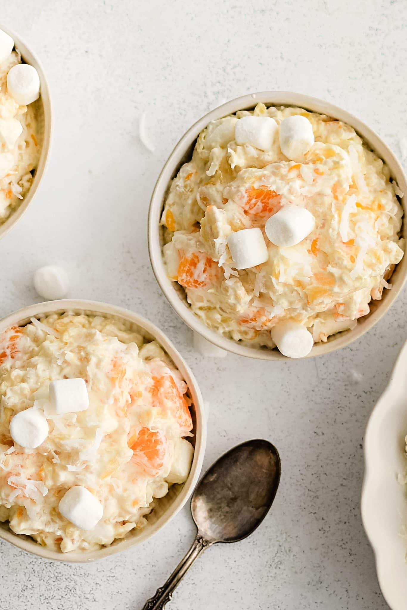 Two small white dessert bowls filled with creamy frog eye salad.