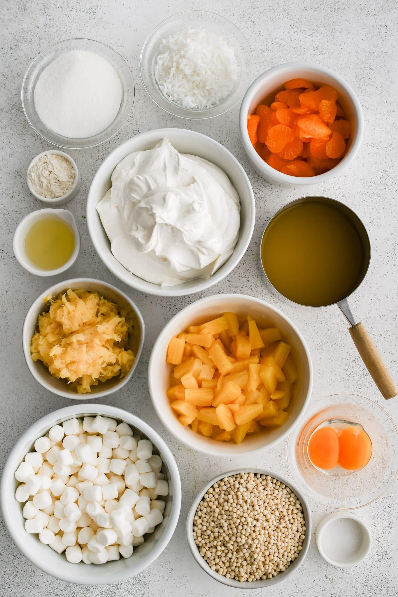 All of the ingredients for homemade Frog Eye Salad presented in individual measuring cups and ramekins.