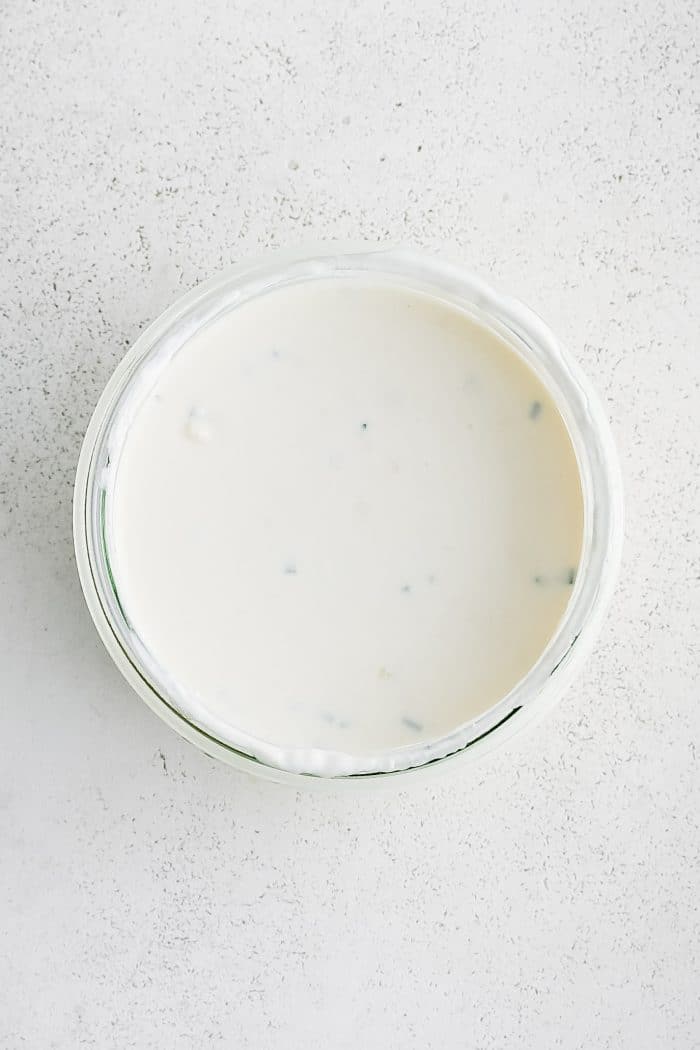 Small glass mixing bowl filled with creamy homemade blue cheese dressing.