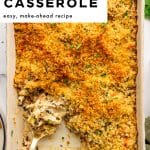 Pinterest pin with large text at the top reading โCHICKEN & WILD RICE CASSEROLEโ and smaller text โeasy, make-ahead recipe,โ over a photo of a beige casserole dish filled with chicken and wild rice casserole topped with golden buttery panko and chopped parsley, with a gold serving spoon in the dish and a green napkin on the side.