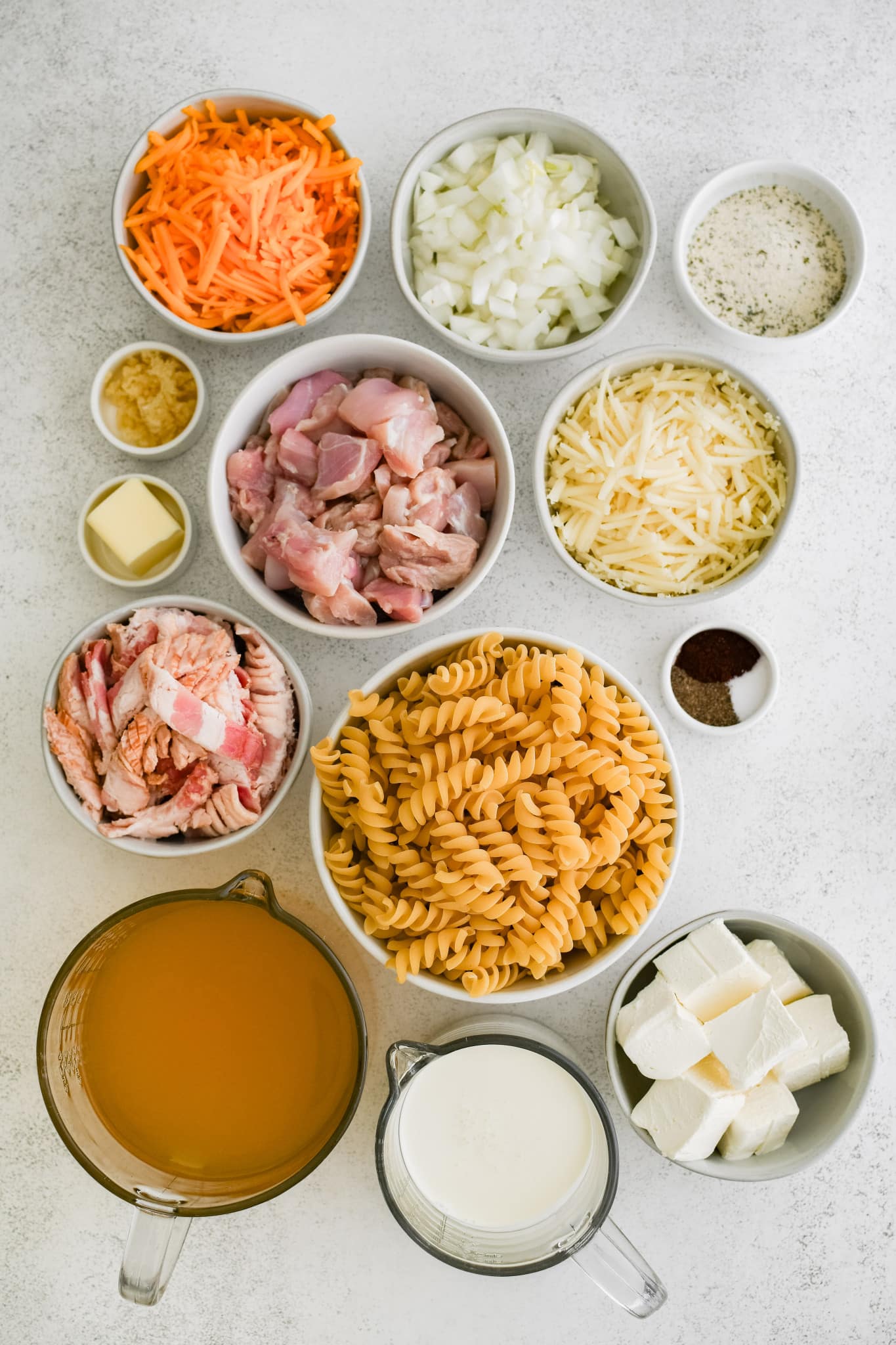 All of the ingredients needed to make chicken bacon ranch pasta in individual measuring cups and ramekins.