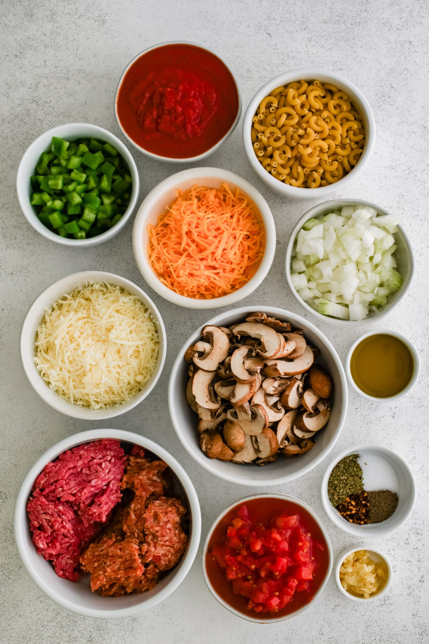 All of the ingredients needed to make Johnny Marzetti in individual measuring cups and ramekins.