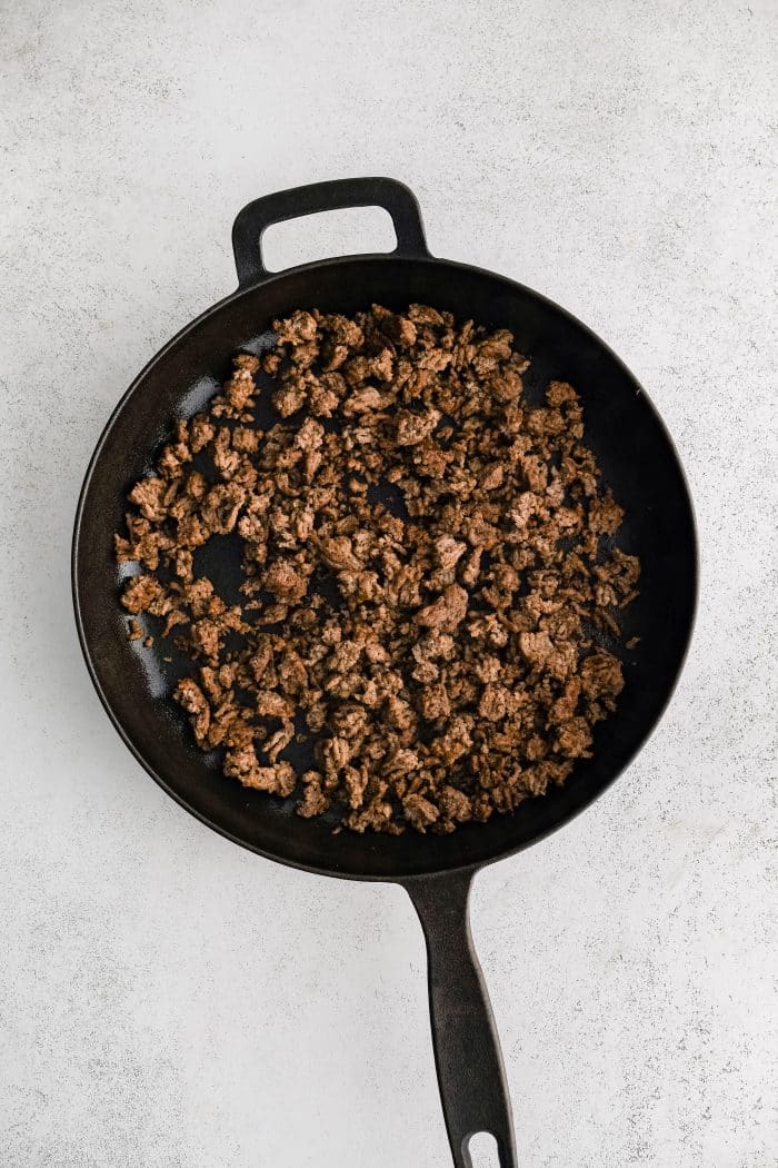 Cooked ground beef in a large cast iron skillet.