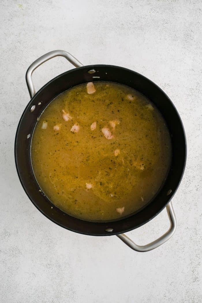 Large soup pot filled with simmering pasta, bacon. and veggies in ranch-seasoned broth.