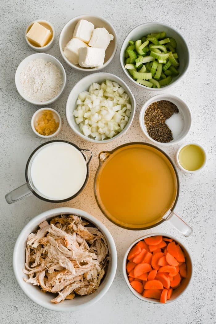 All of the ingredients needed to make creamy chicken soup on the stovetop in individual measuring cups and ramekins.