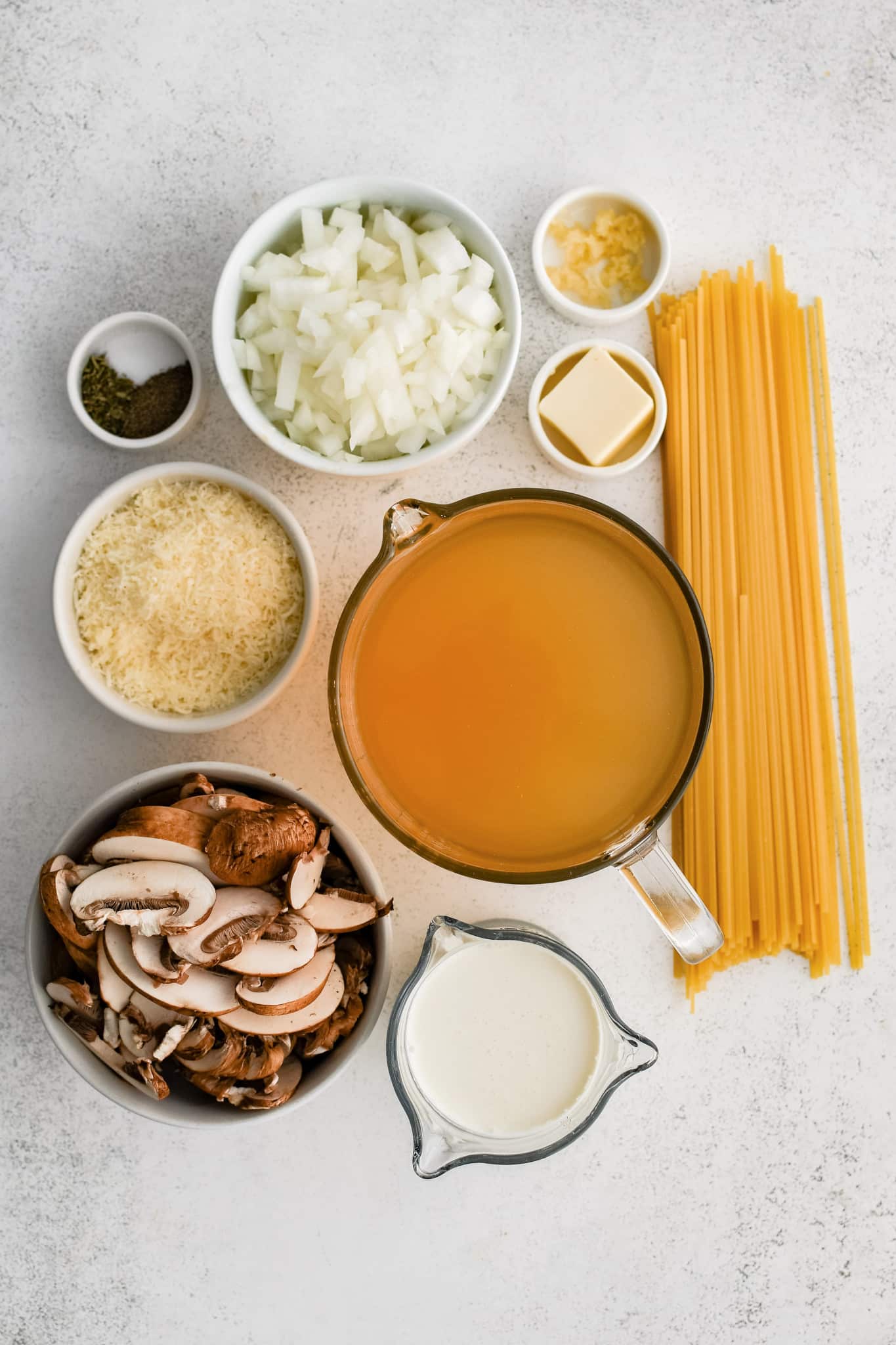 All of the ingredients needed to make creamy mushroom pasta in individual measuring cups and ramekins.