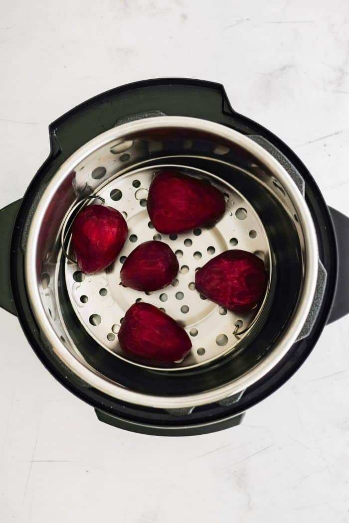 Instant Pot with five medium-sized peeled raw red beets.