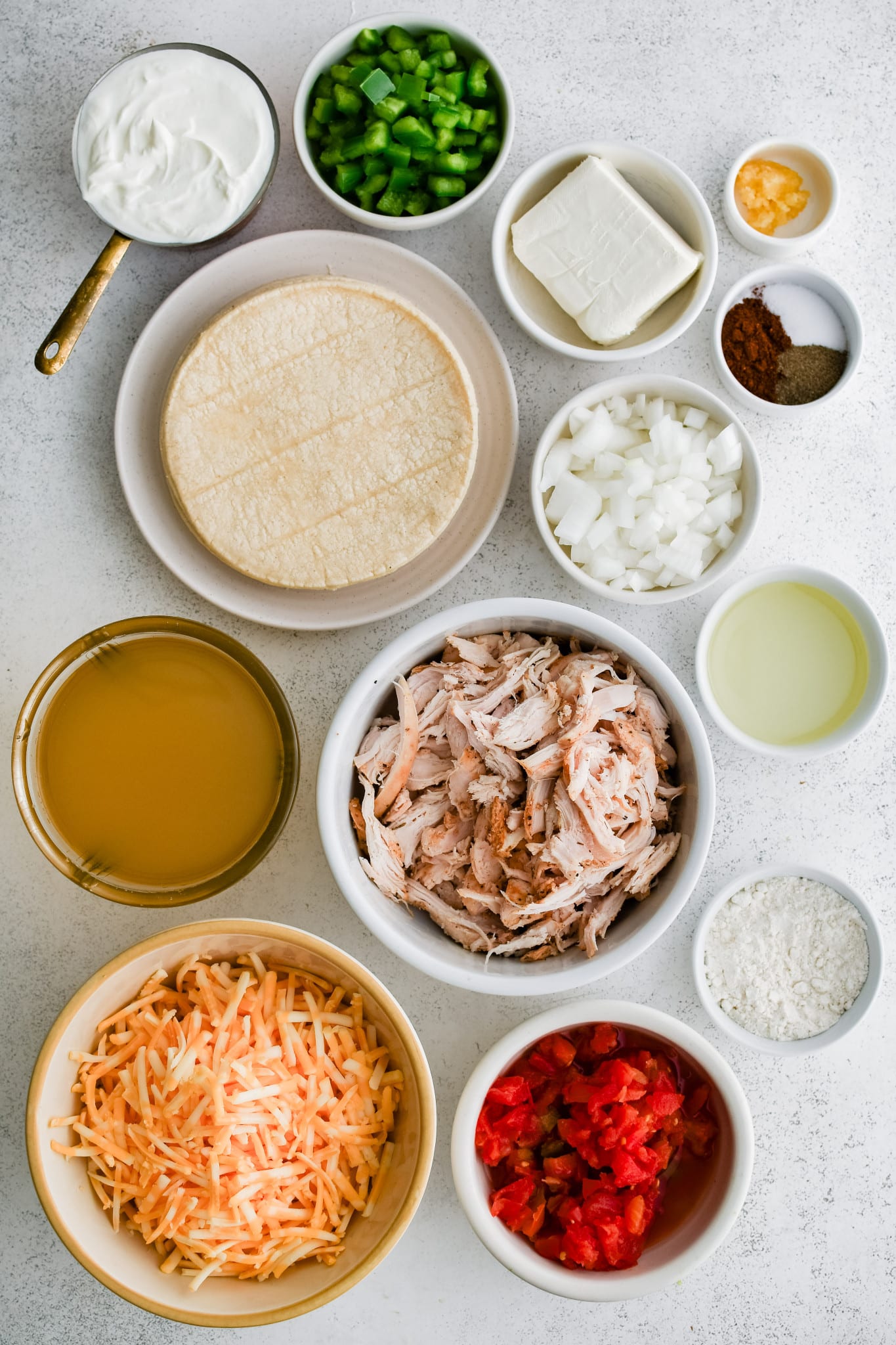 All of the ingredients needed to make King Ranch chicken casserole in individual measuring cups and ramekins.