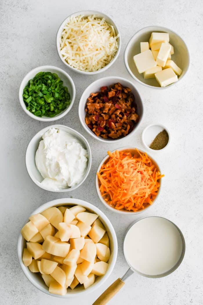 All of the ingredients needed to make loaded mashed potato casserole in individual measuring cups and ramekins.