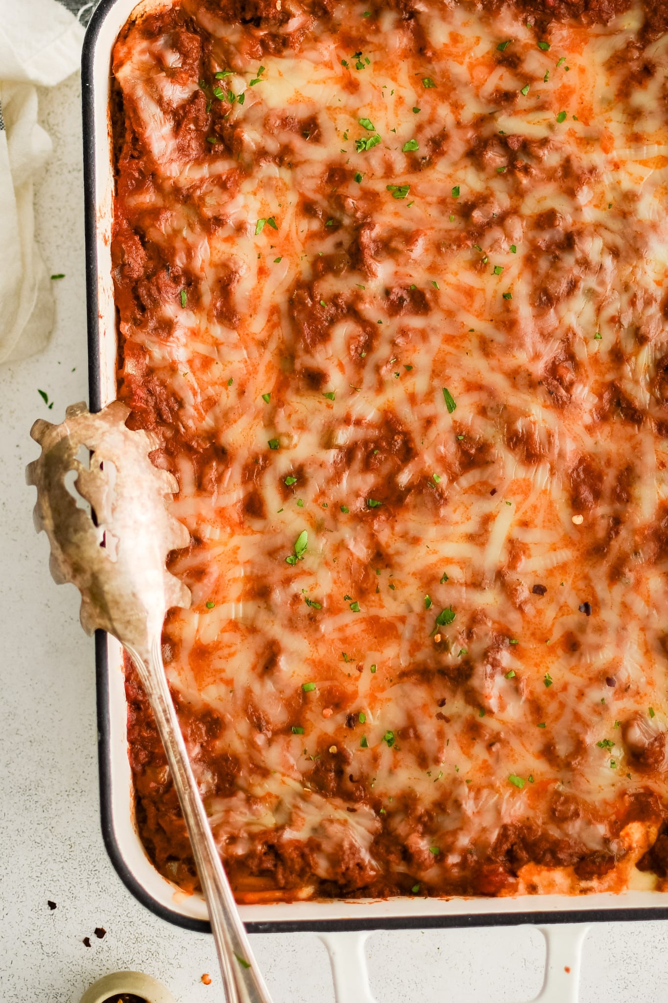 Baked million dollar casserole garnished with fresh chopped parsley.