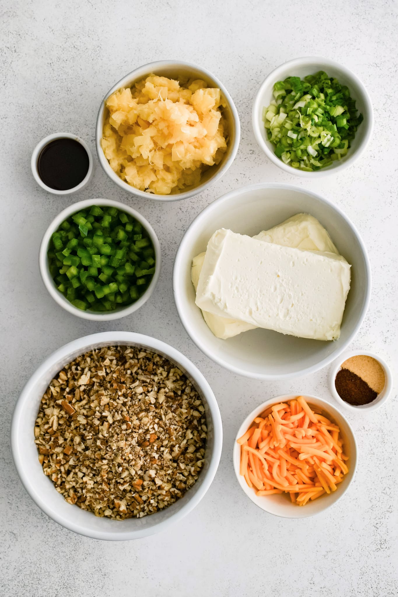 All of the ingredients needed to make Pineapple Cheese Ball in individual measuring cups and ramekins.