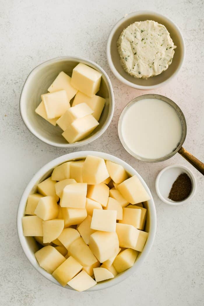 All of the ingredients needed to make Boursin mashed potatoes in individual measuring cups and ramekins.