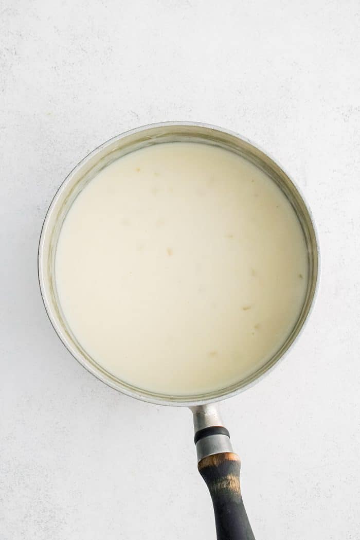 Medium saucepan filled with homemade creamy onion sauce.