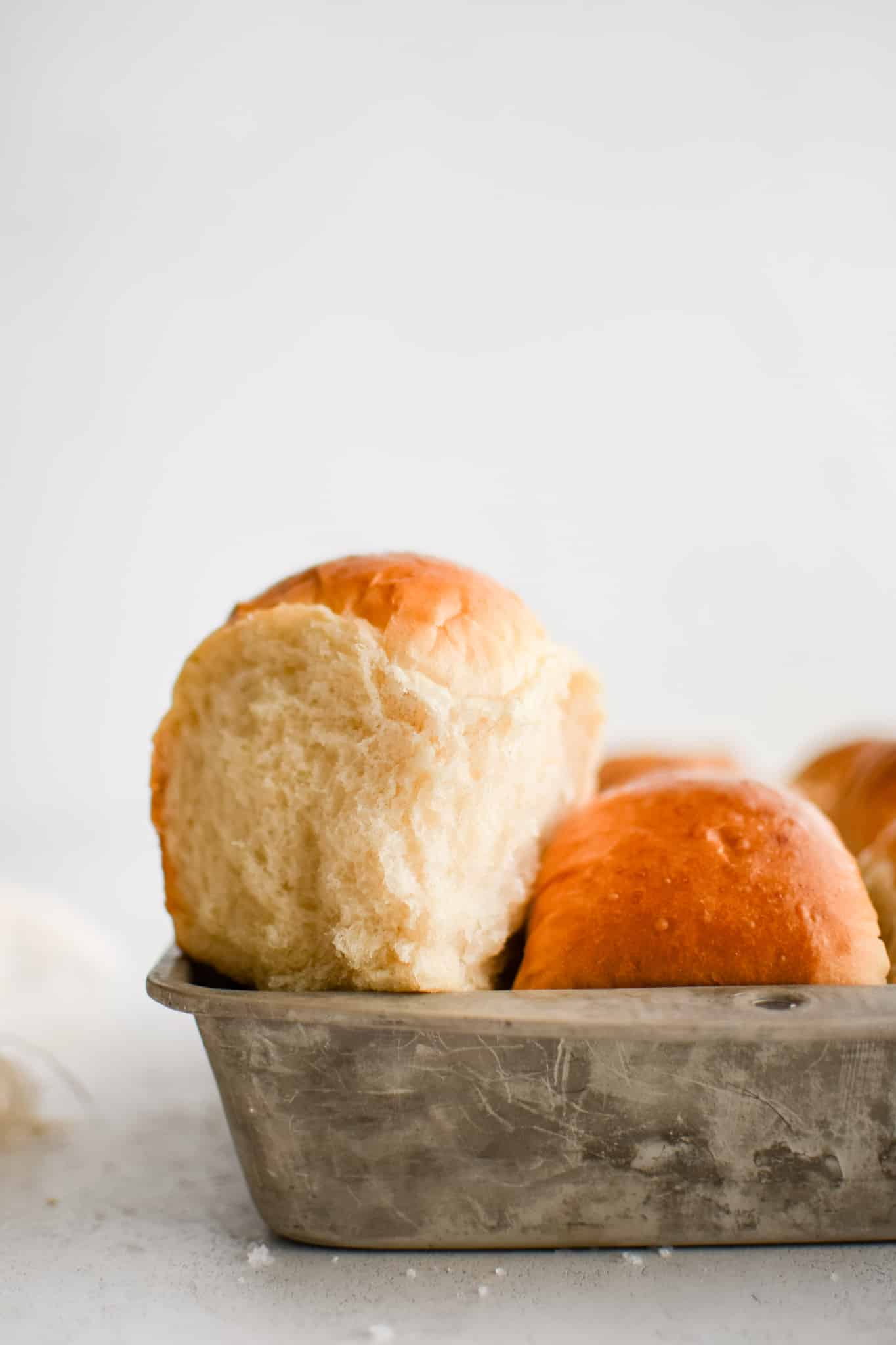 Baking pan filled with perfectly soft, fluffy, and flaky dinner rolls with buttery golden tops.
