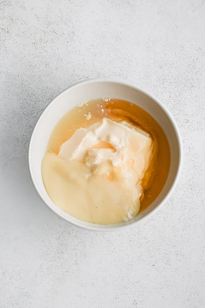 Mayonnaise, sweetened condensed milk, honey, and lemon juice in a small bowl.